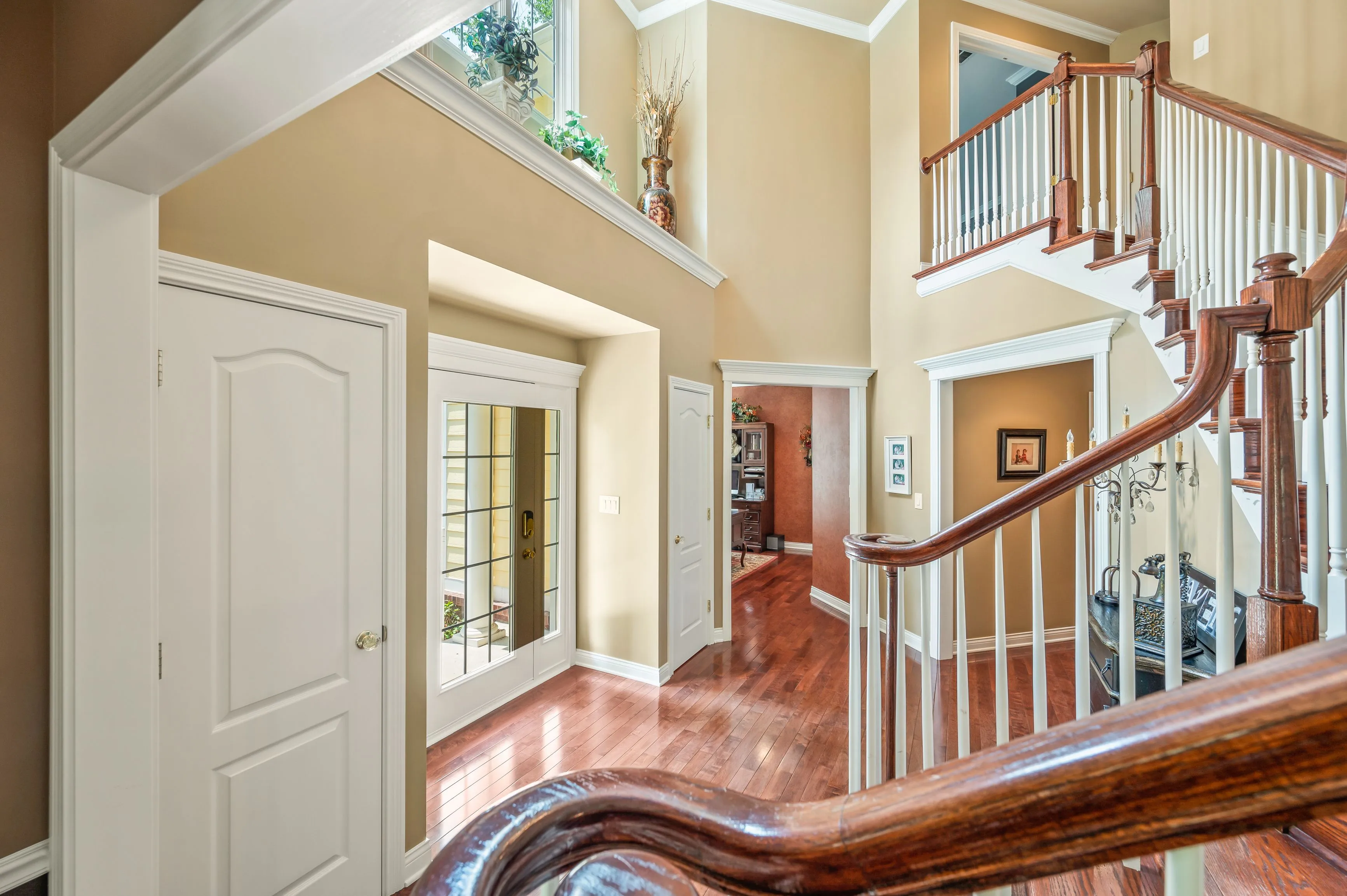 Interior view of a home entryway with staircase and hardwood floors.