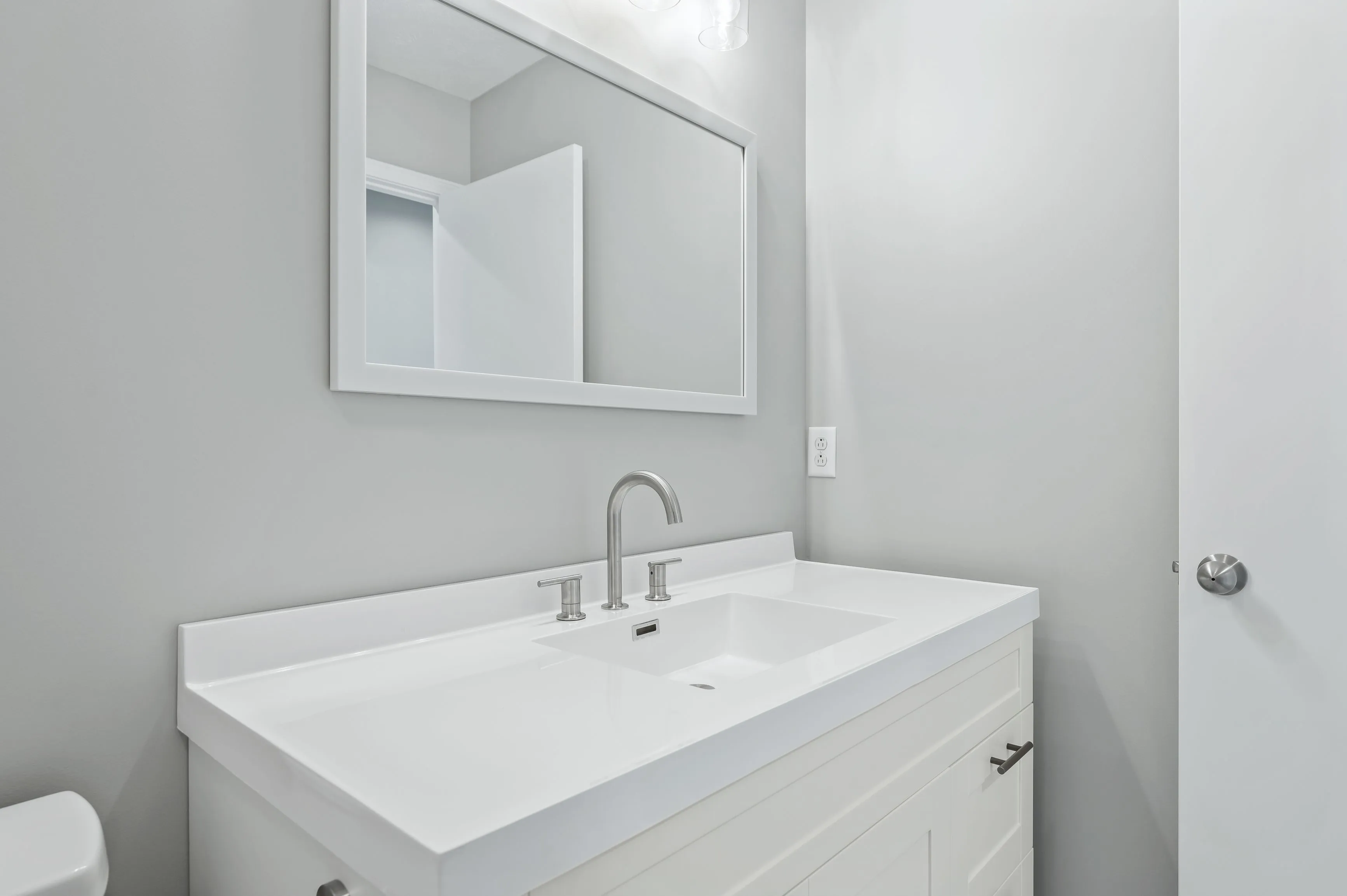 Modern white bathroom interior with sink and mirror.