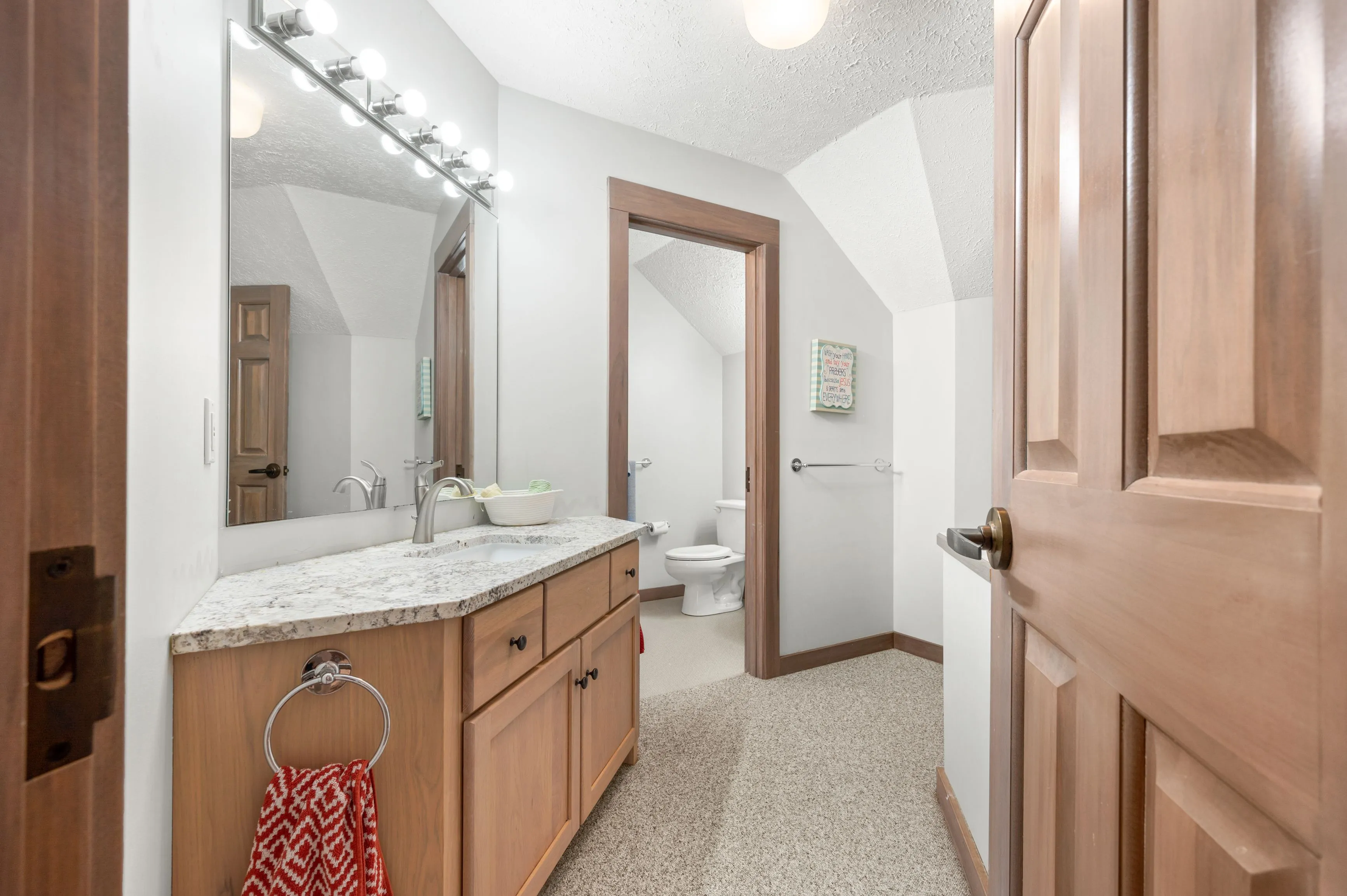 Modern bathroom interior with dual sinks, large mirror, and terrazzo flooring.