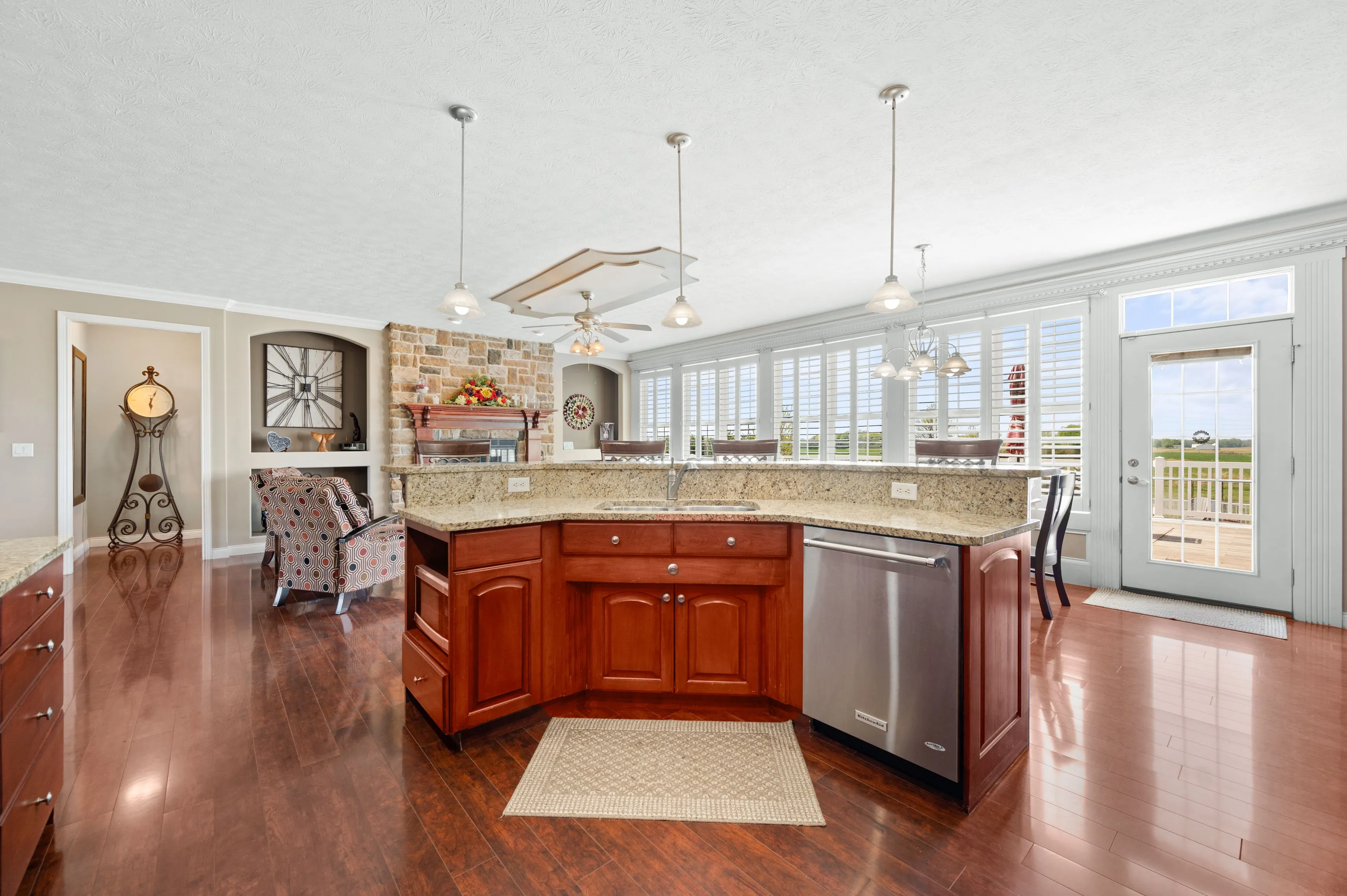 Spacious kitchen with cherry wood cabinets, stainless steel appliances, and glossy hardwood floors.
