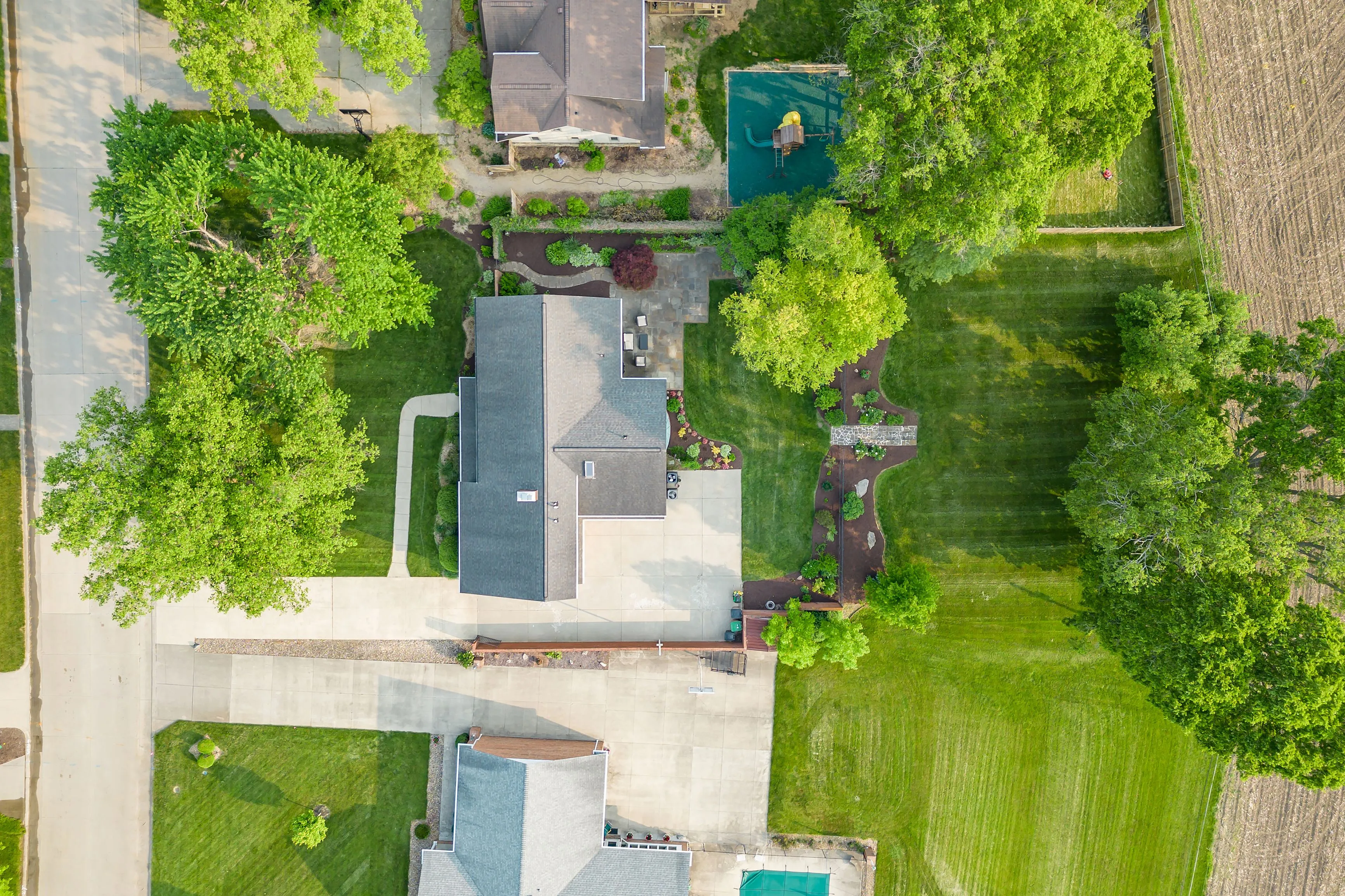 Aerial view of a suburban home with a swimming pool and green backyard.