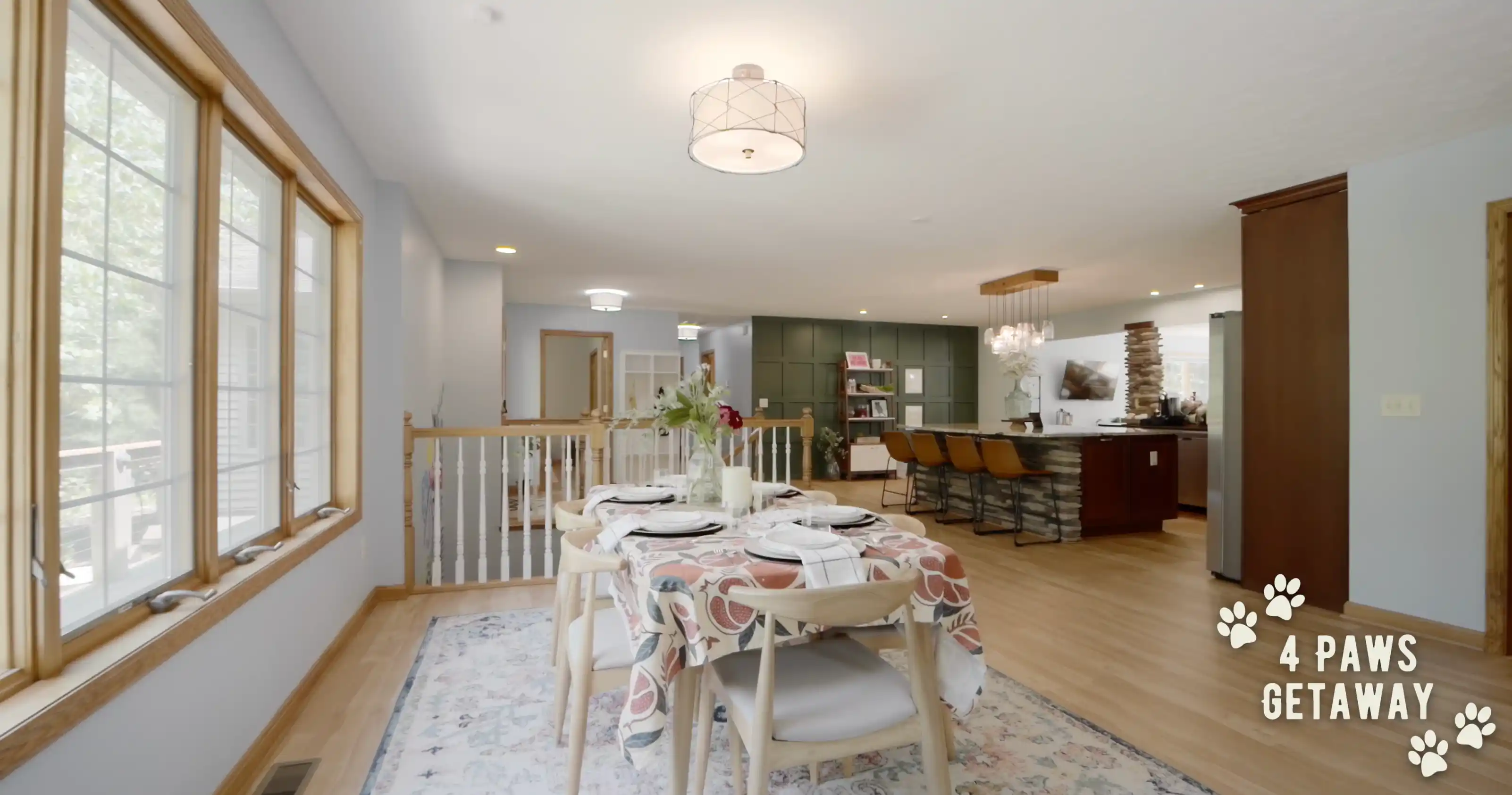 Bright and welcoming dining area leading to a kitchen inside the "4 Paws Getaway" home, showing a dining table set near windows with natural light, and a glimpse of the kitchen in the background.