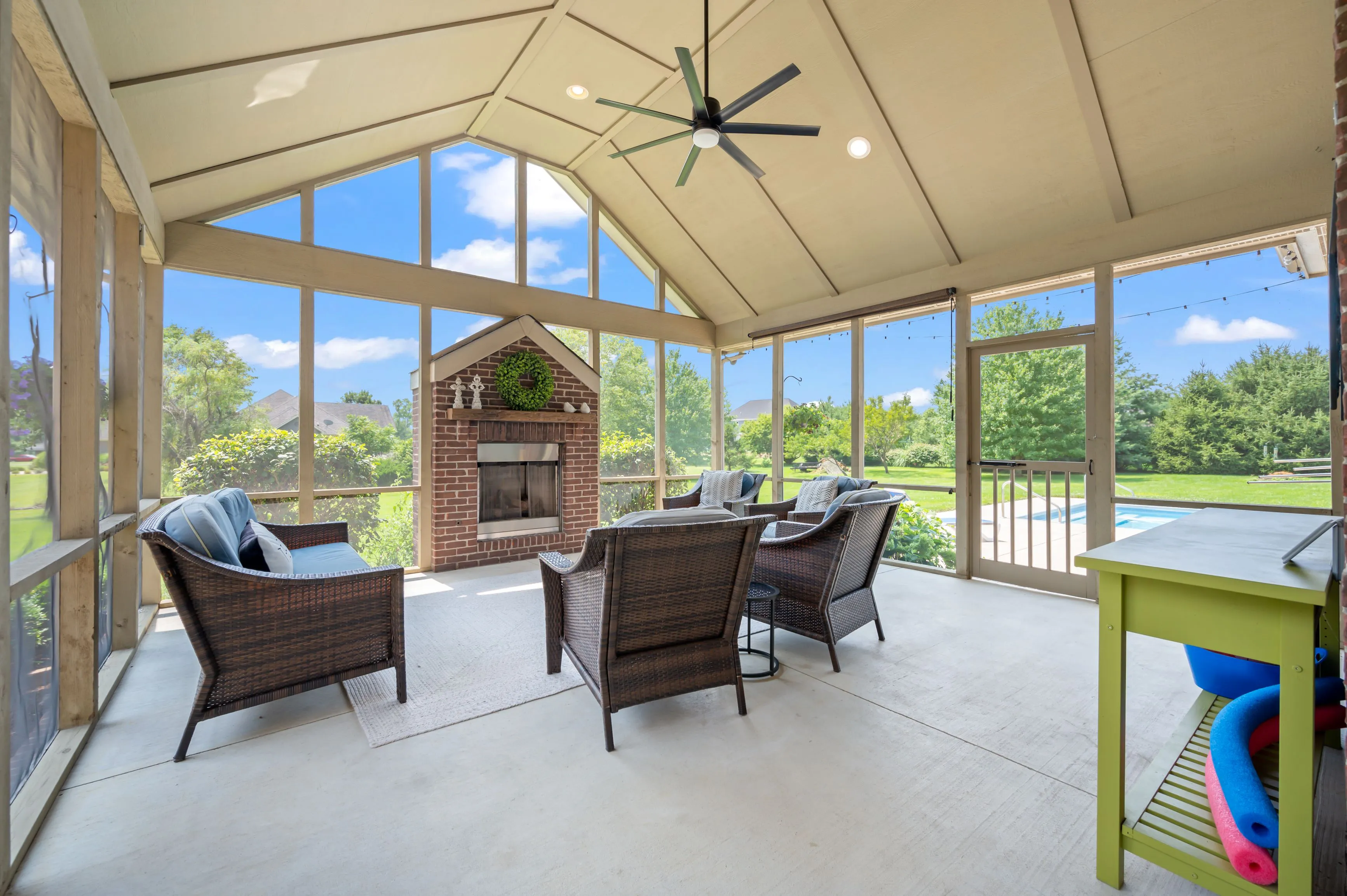 Screened porch with outdoor furniture and a view of the backyard.