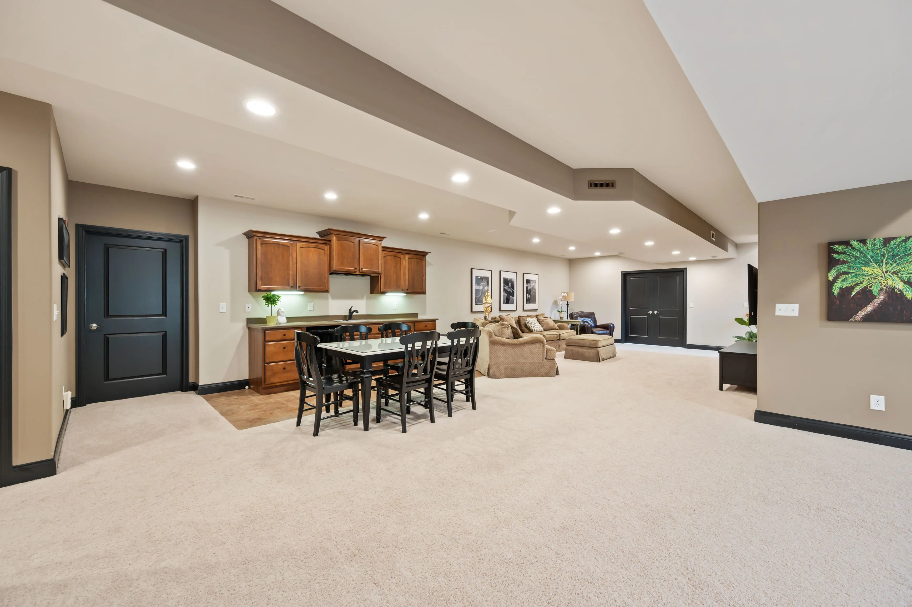 Spacious modern open concept living area with kitchen, dining space, and living room, featuring hardwood floors, recessed lighting, and contemporary furnishings.