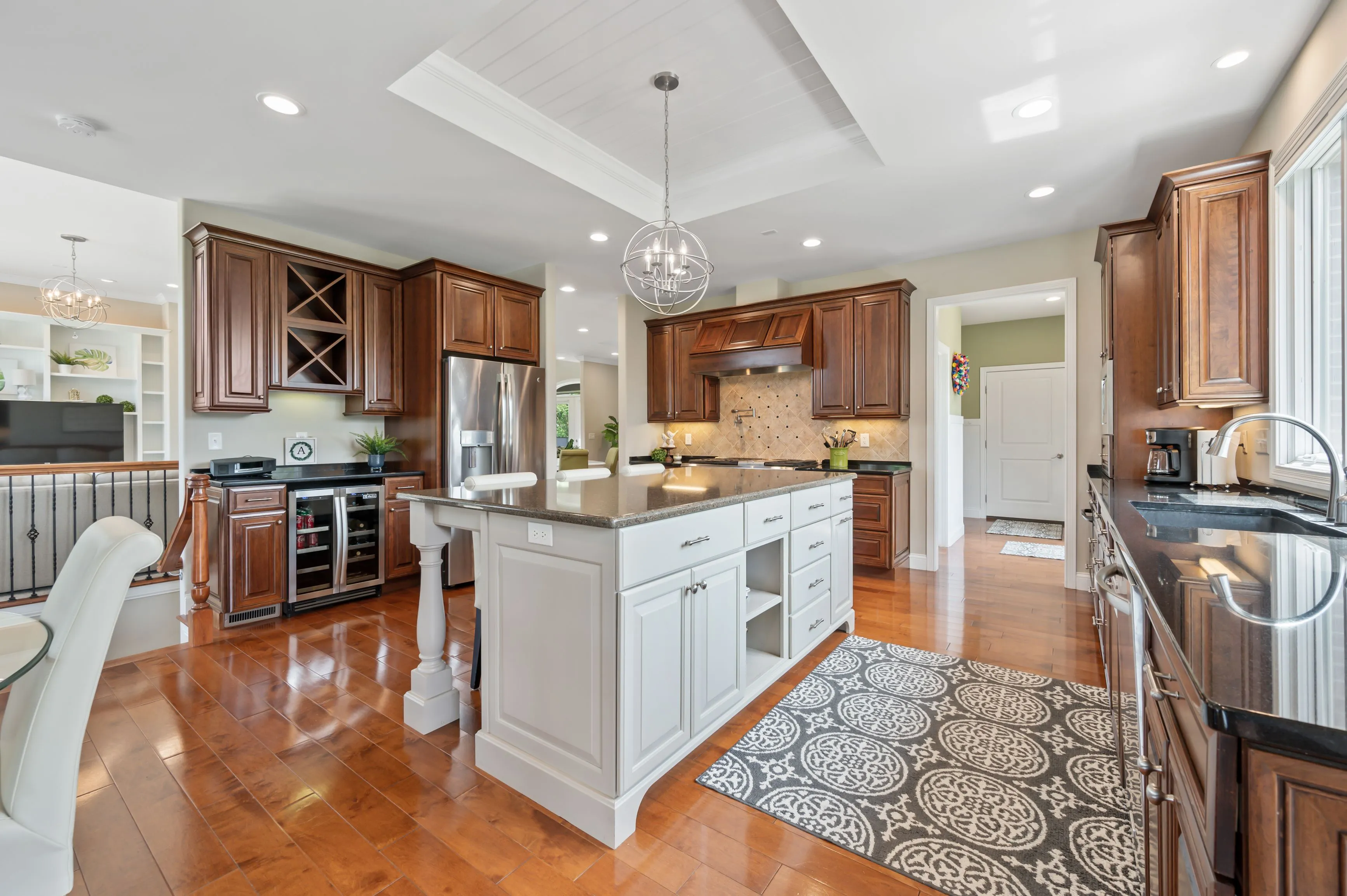 Spacious kitchen interior with wooden cabinets, central island, and hardwood floors.