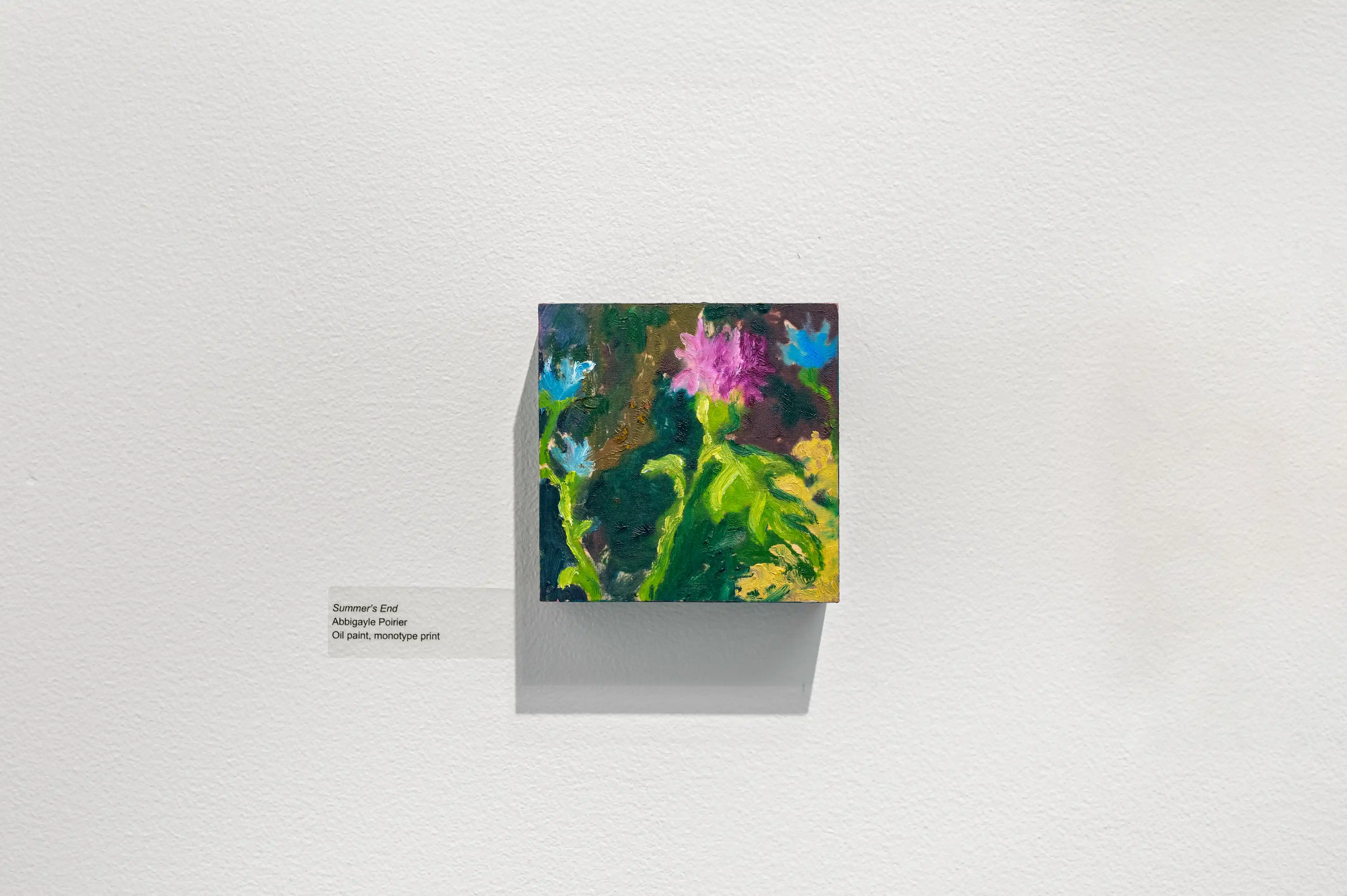 Abstract colorful painting displayed on a white pedestal in a gallery setting with descriptive placard on the wall.