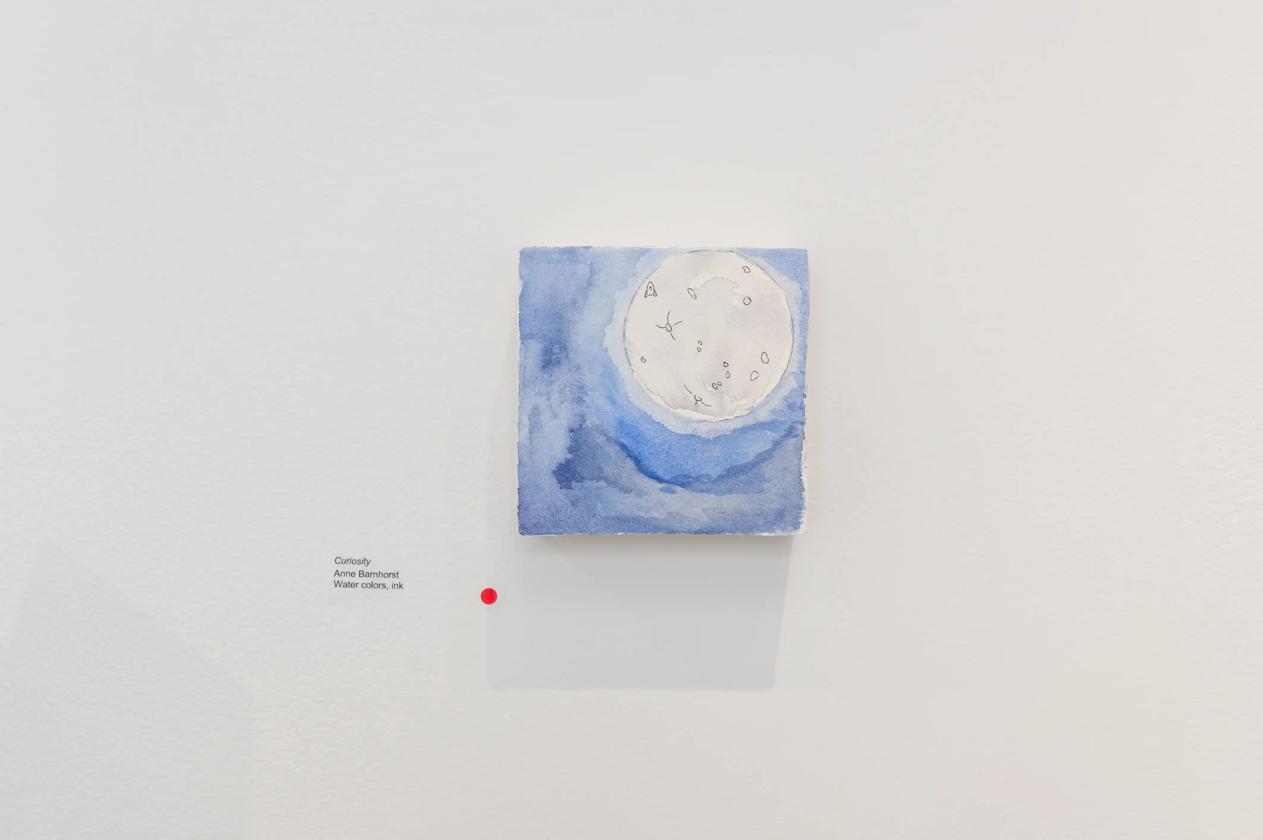 Abstract blue and white painting displayed on a gallery wall with an information placard to the side.