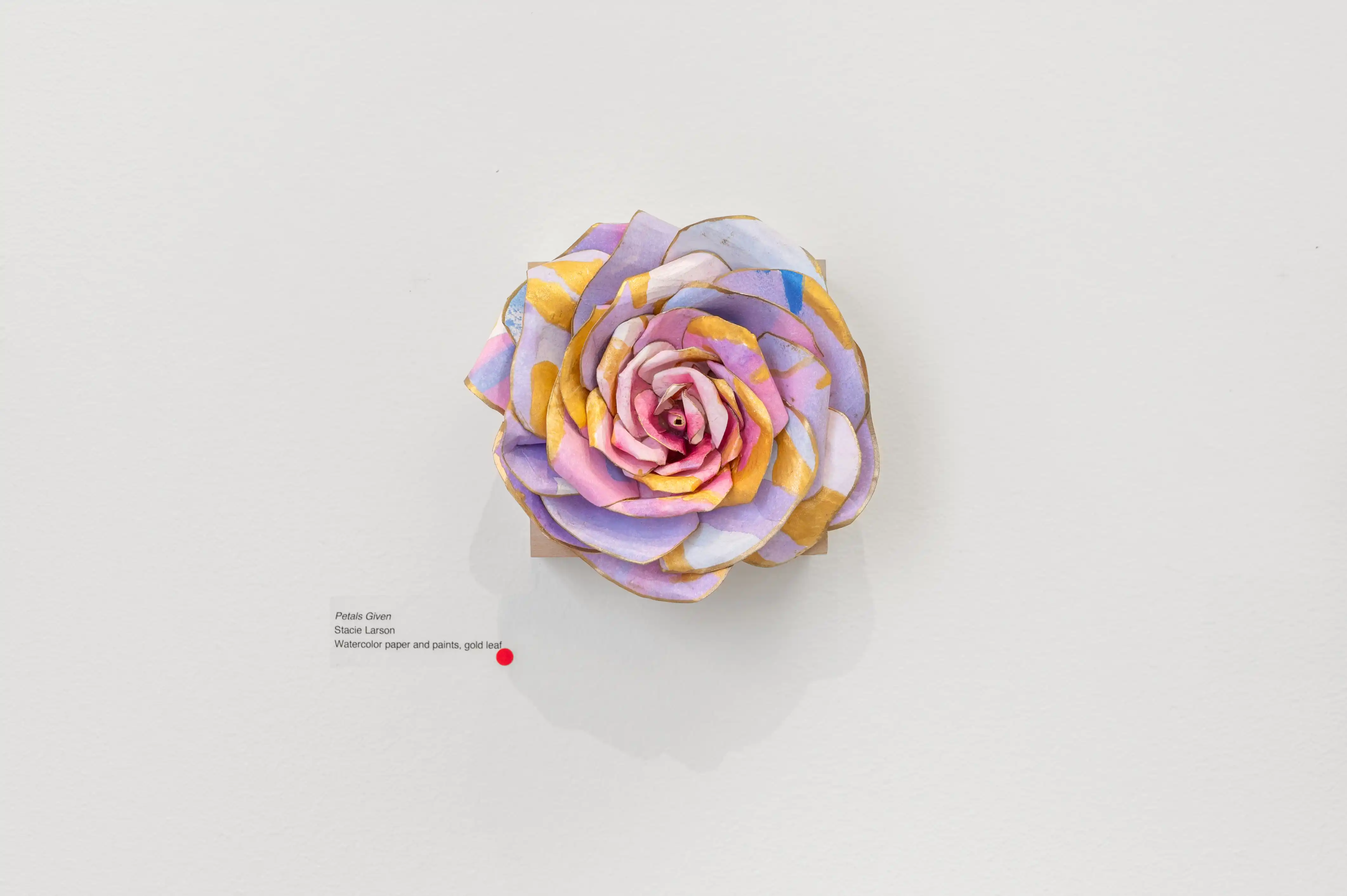 Colorful paper flower sculpture with a gradient from purple to pink on a white background.