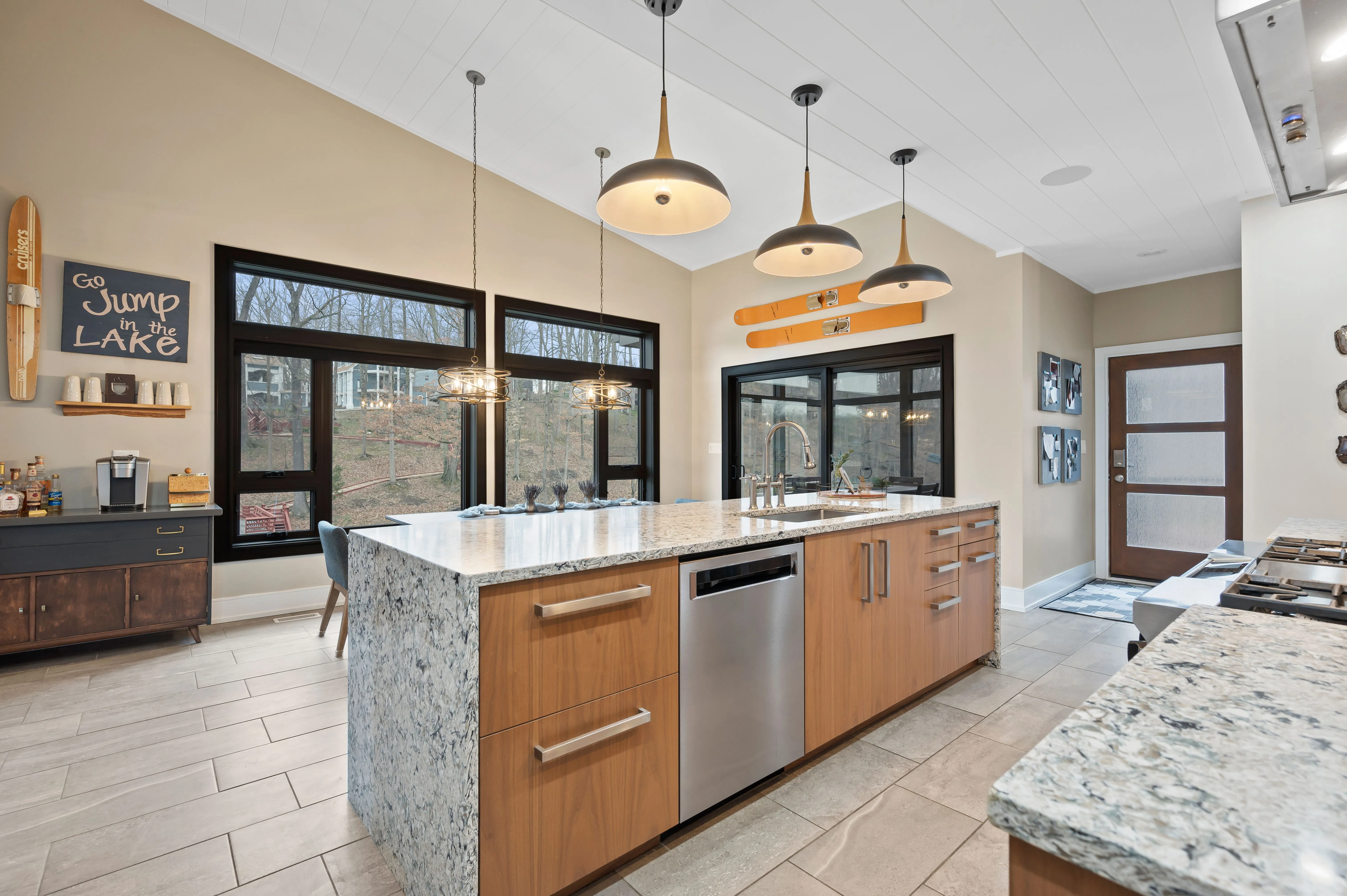 Modern kitchen interior with granite countertops, stainless steel appliances, and pendant lighting.