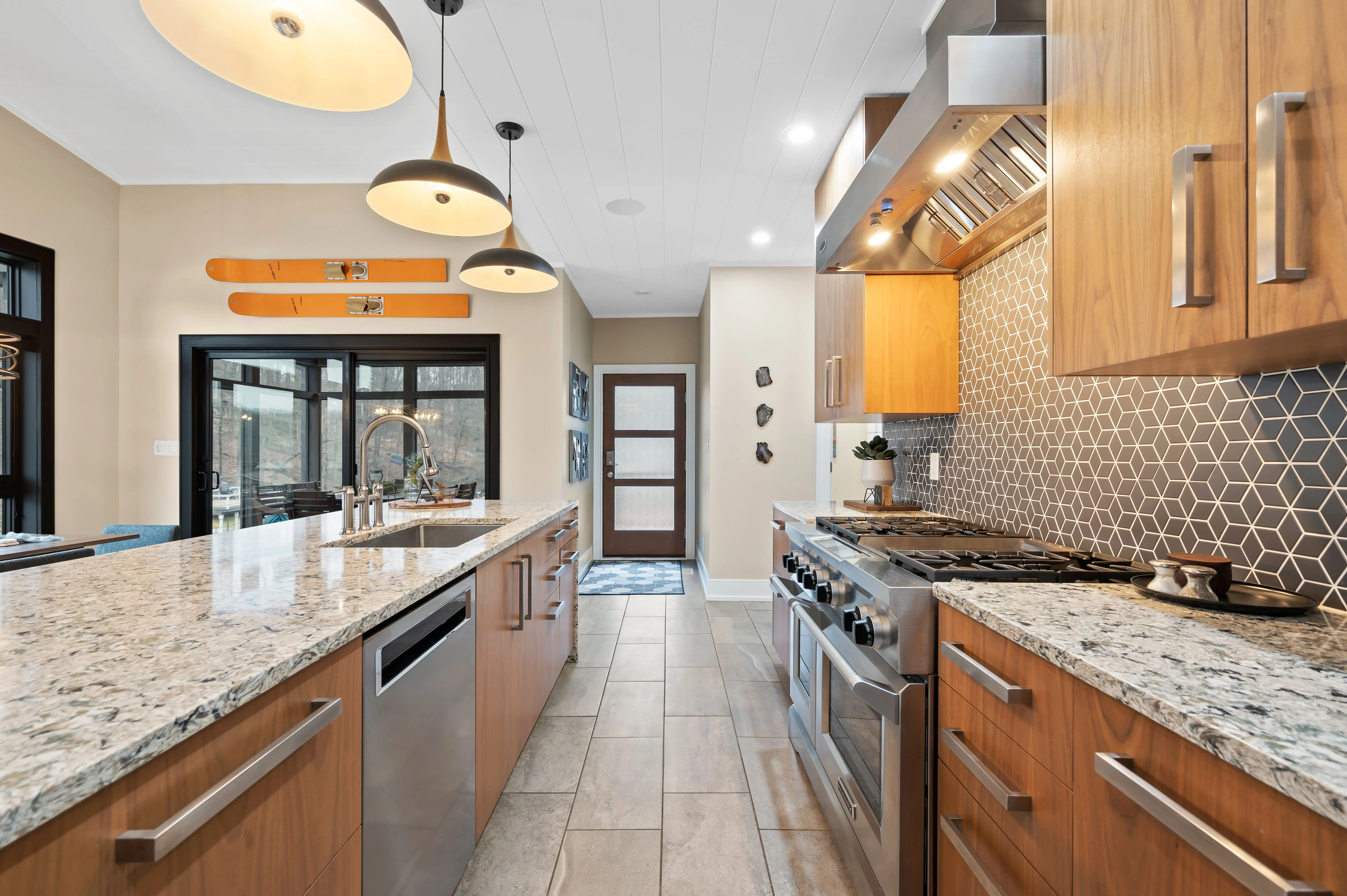 Modern kitchen interior with granite countertops, wooden cabinetry, and stainless steel appliances.