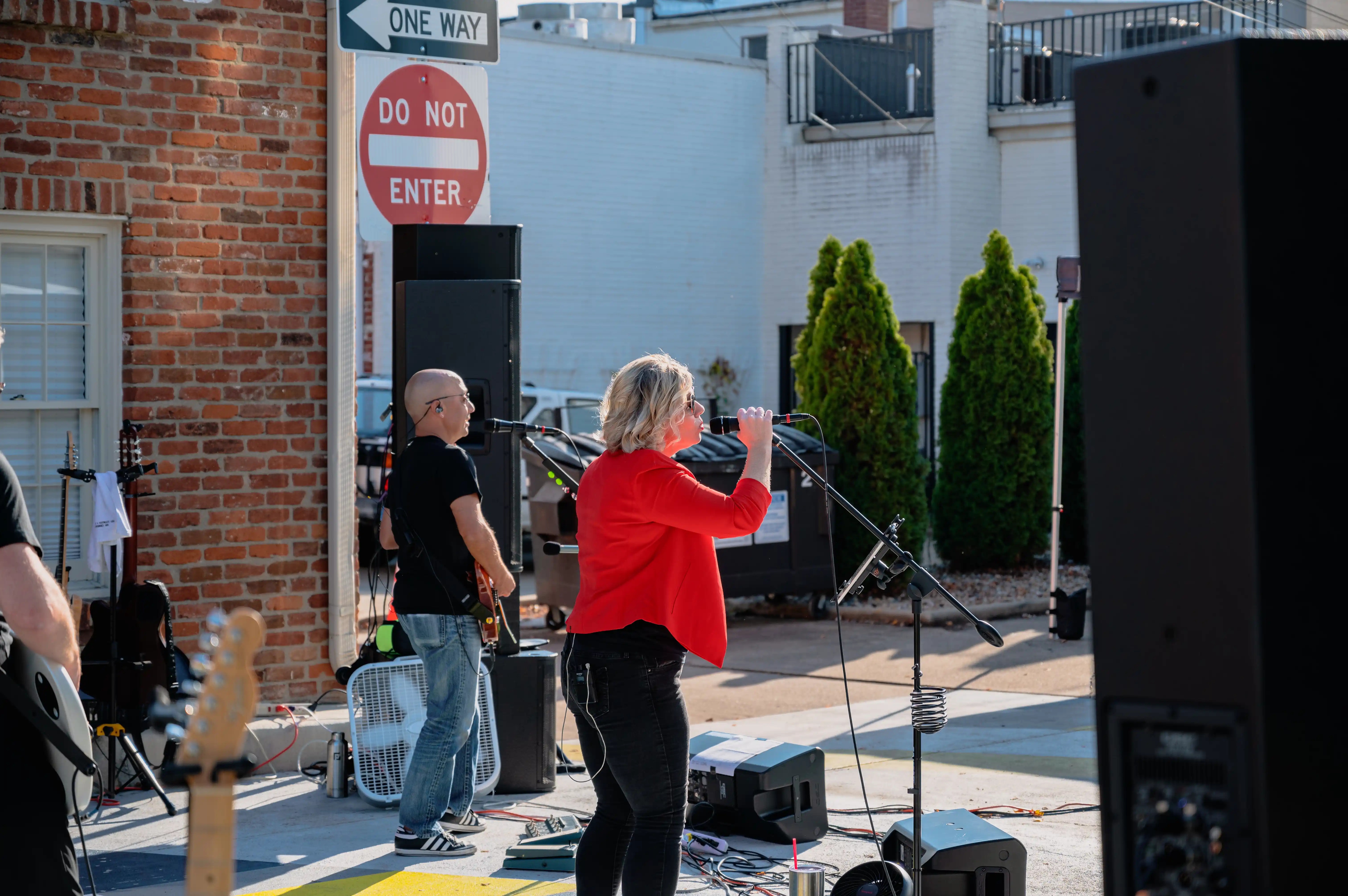 A band performing at an outdoor event with a "Do Not Enter" sign visible in the background.
