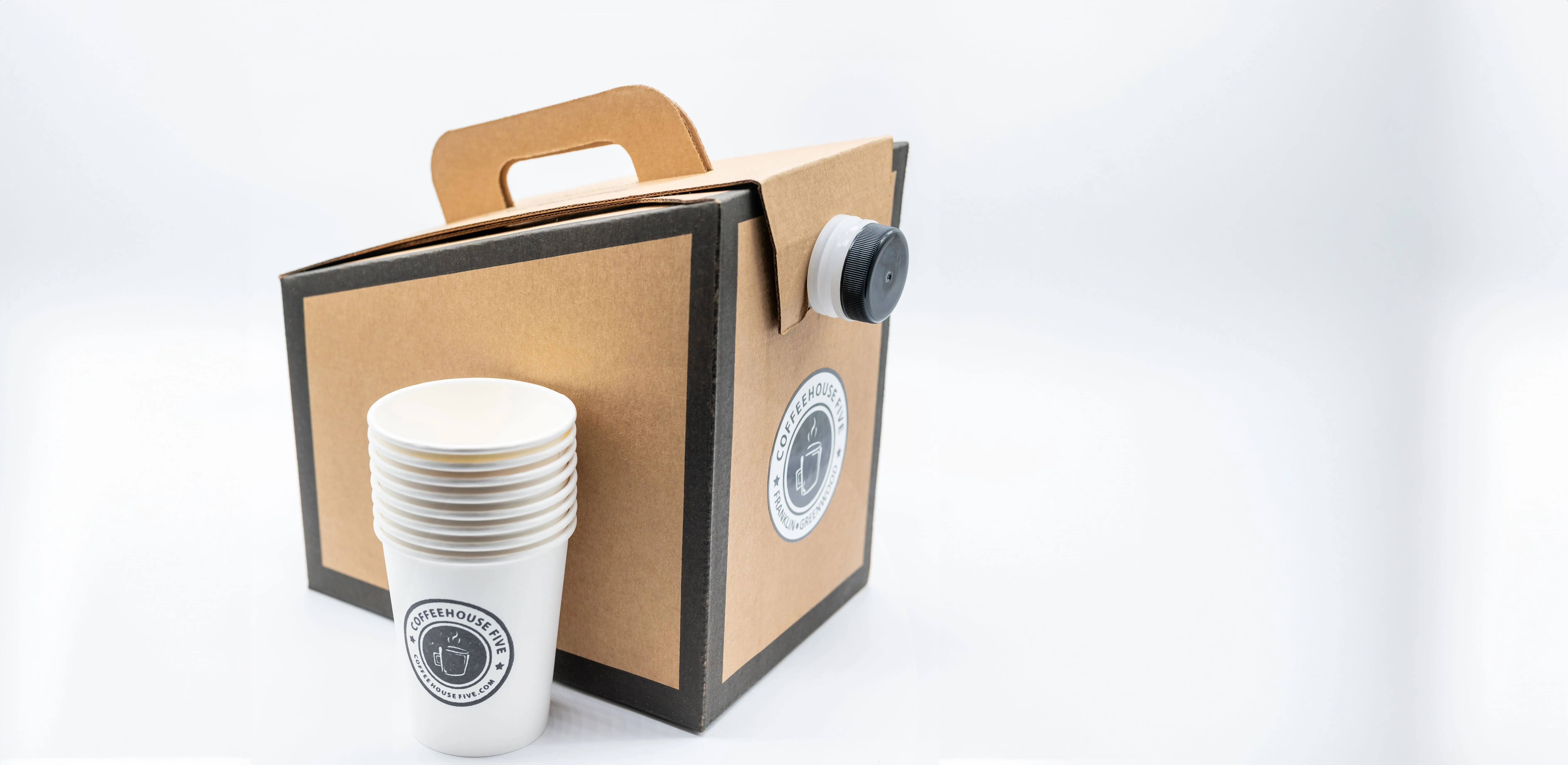 Cardboard portable coffee dispenser with a stack of white paper cups on a white background.