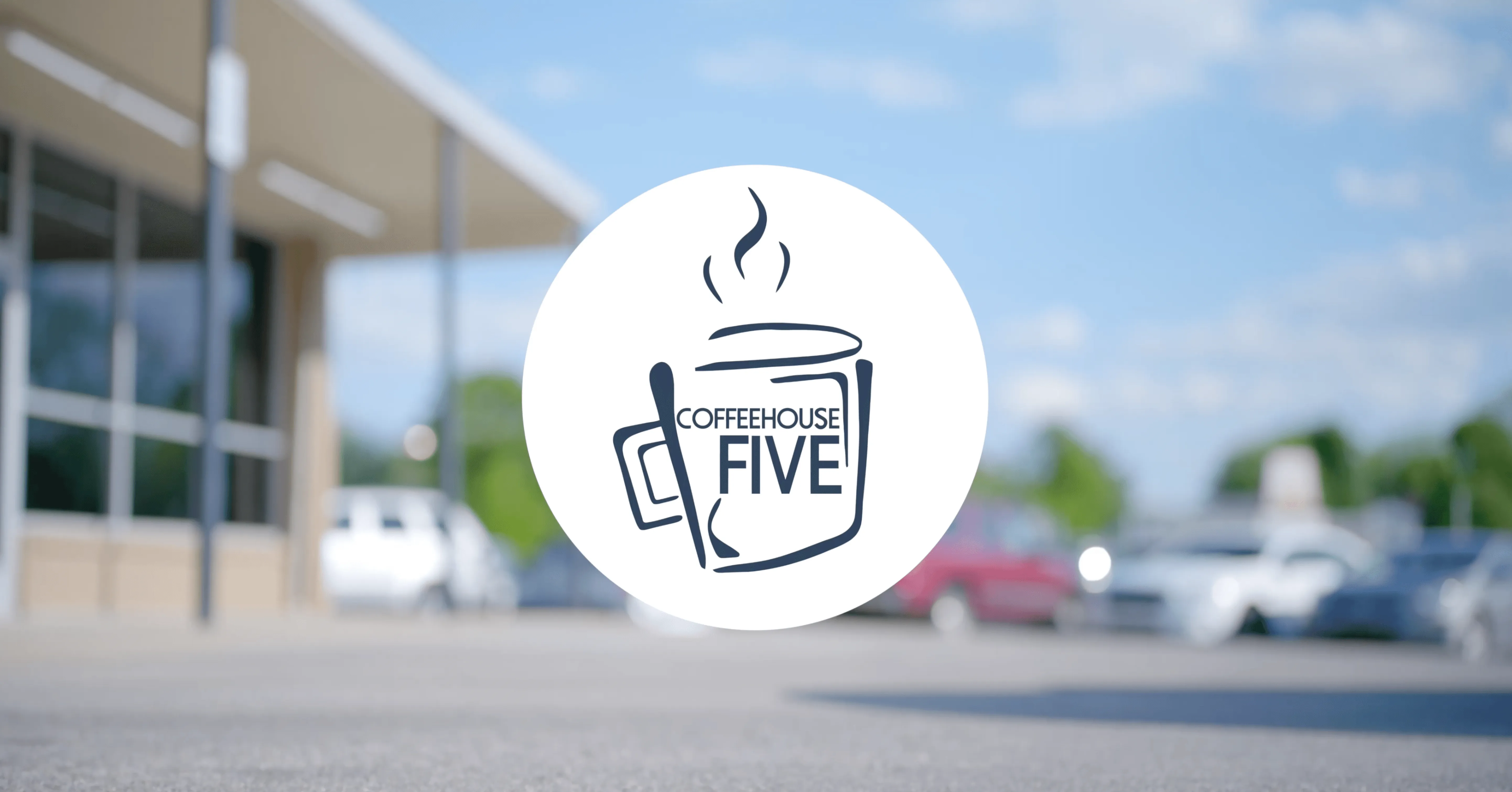 Logo of Coffeehouse Five with a stylized coffee cup design superimposed over a blurry background featuring a building and parked cars.