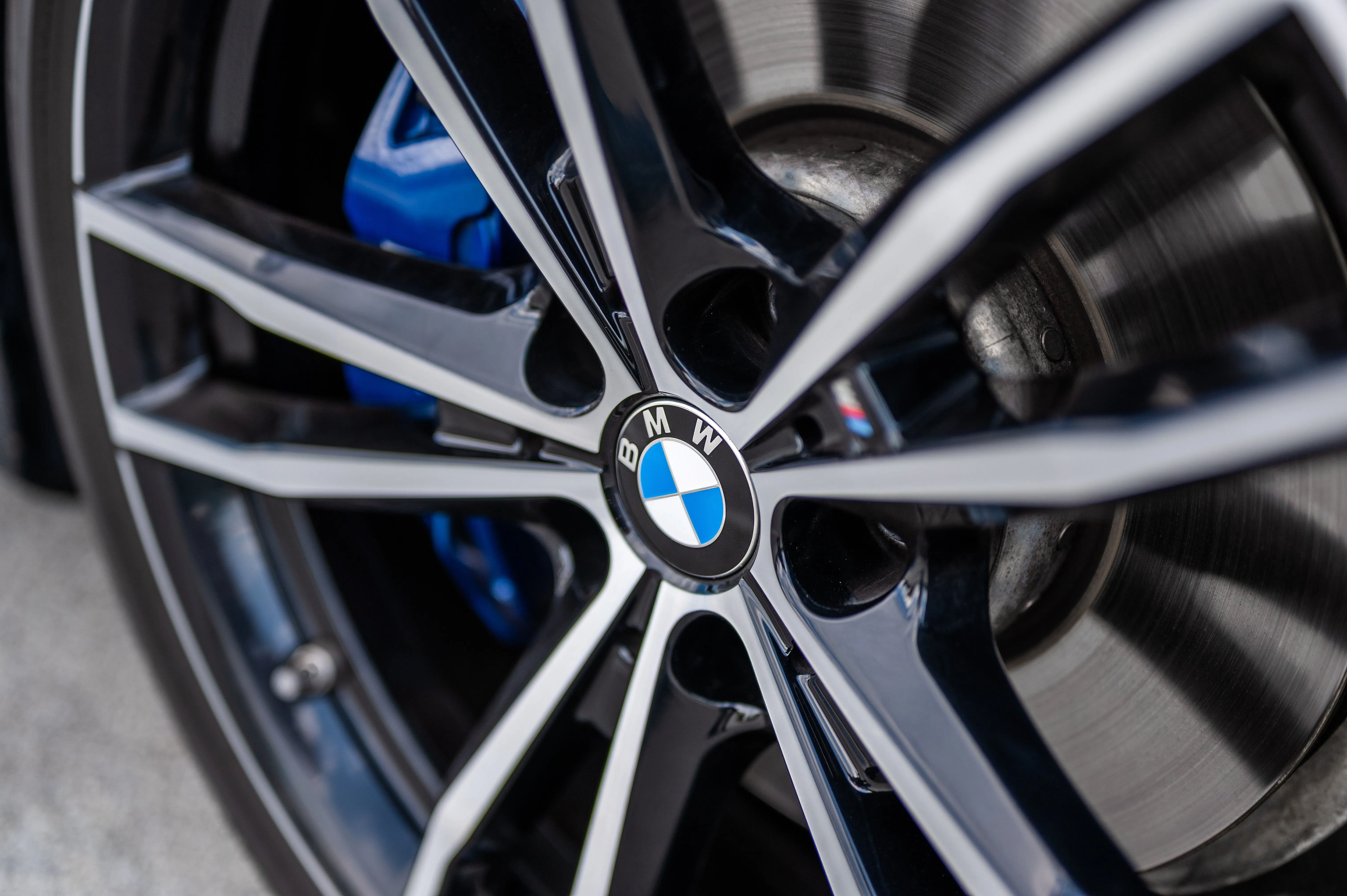 Close-up of a BMW alloy wheel with logo and blue brake caliper.