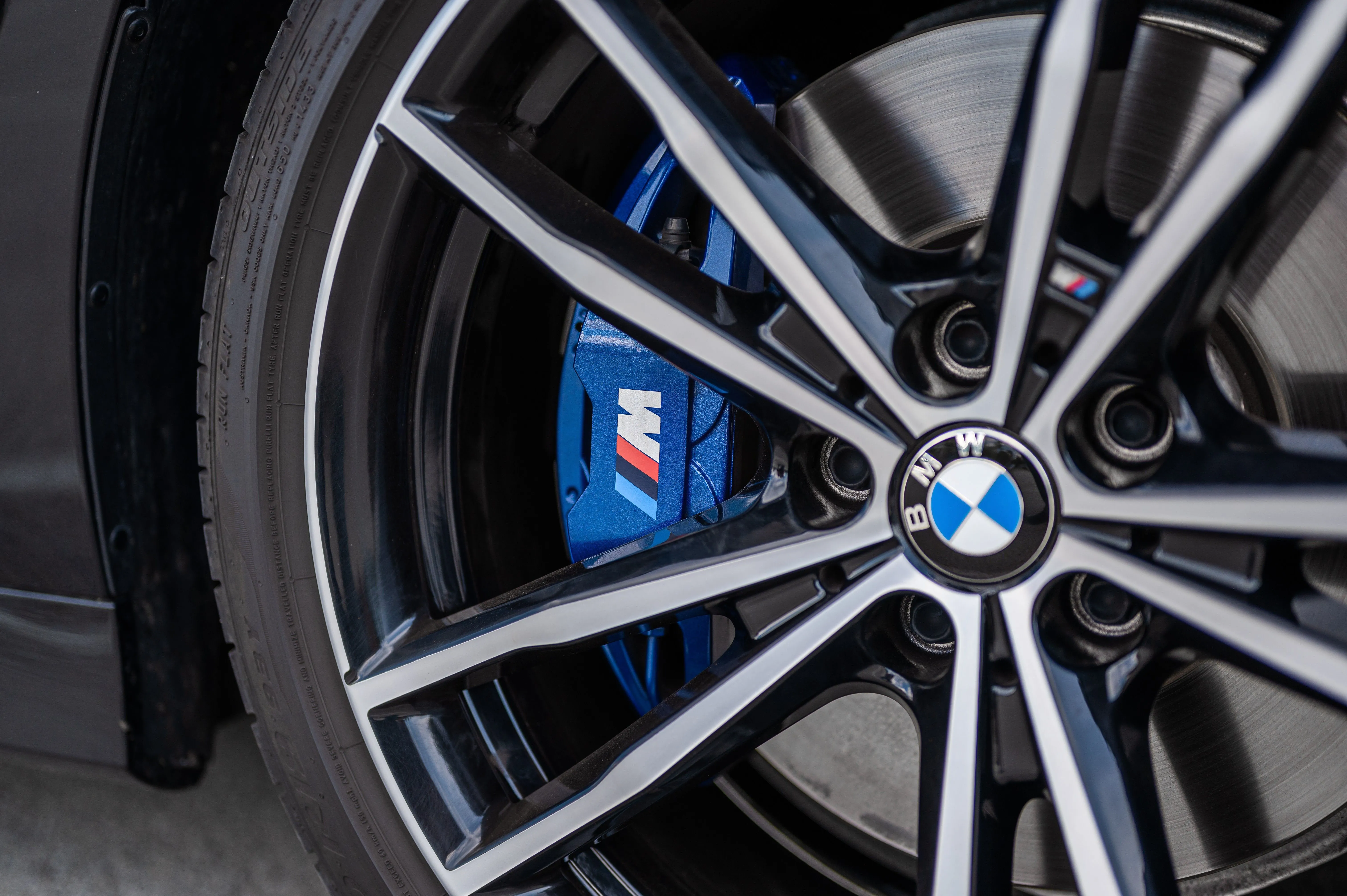 Close-up of a BMW alloy wheel with blue brake caliper.