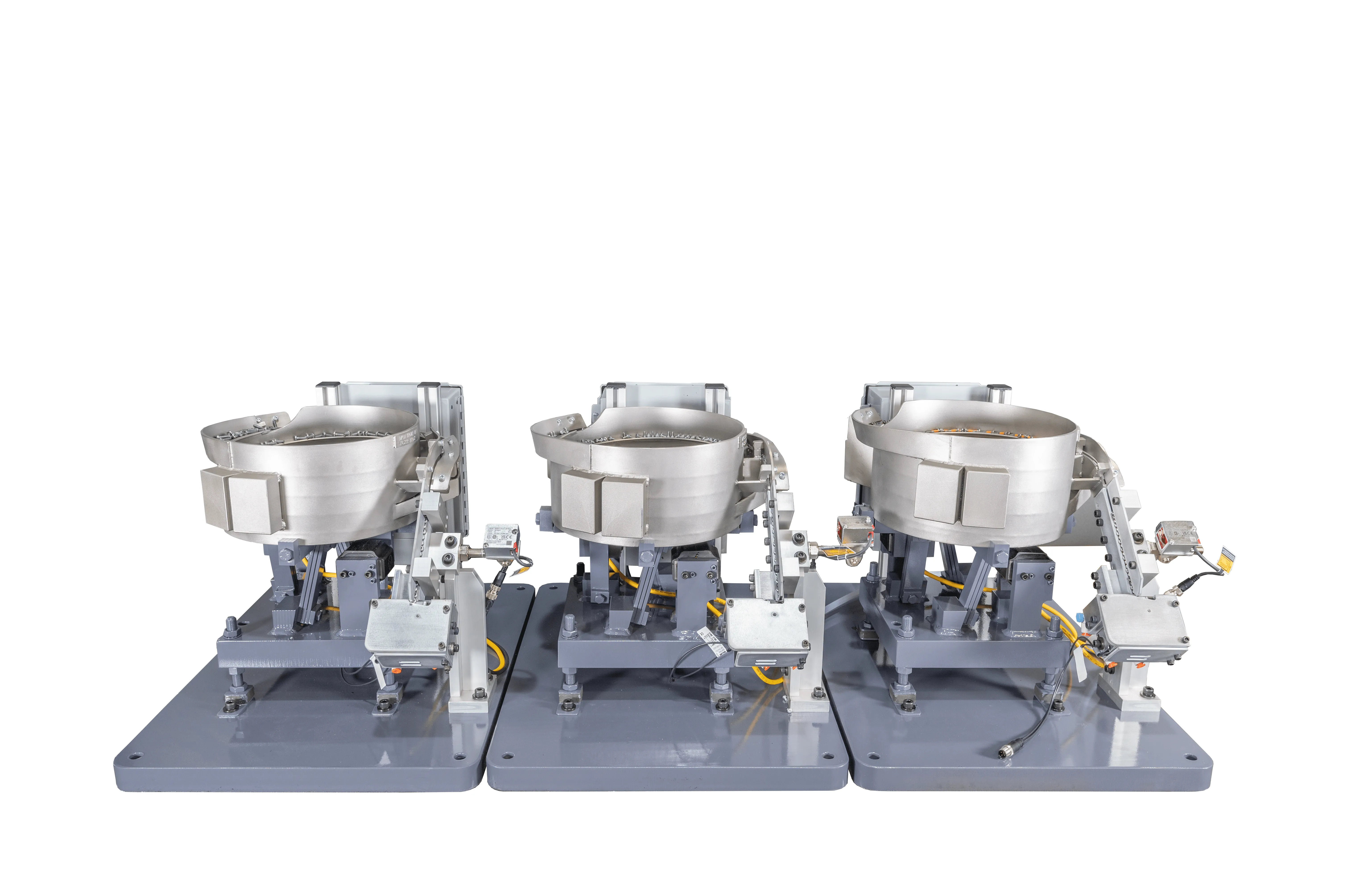Three industrial vibratory bowl feeders on a white background.