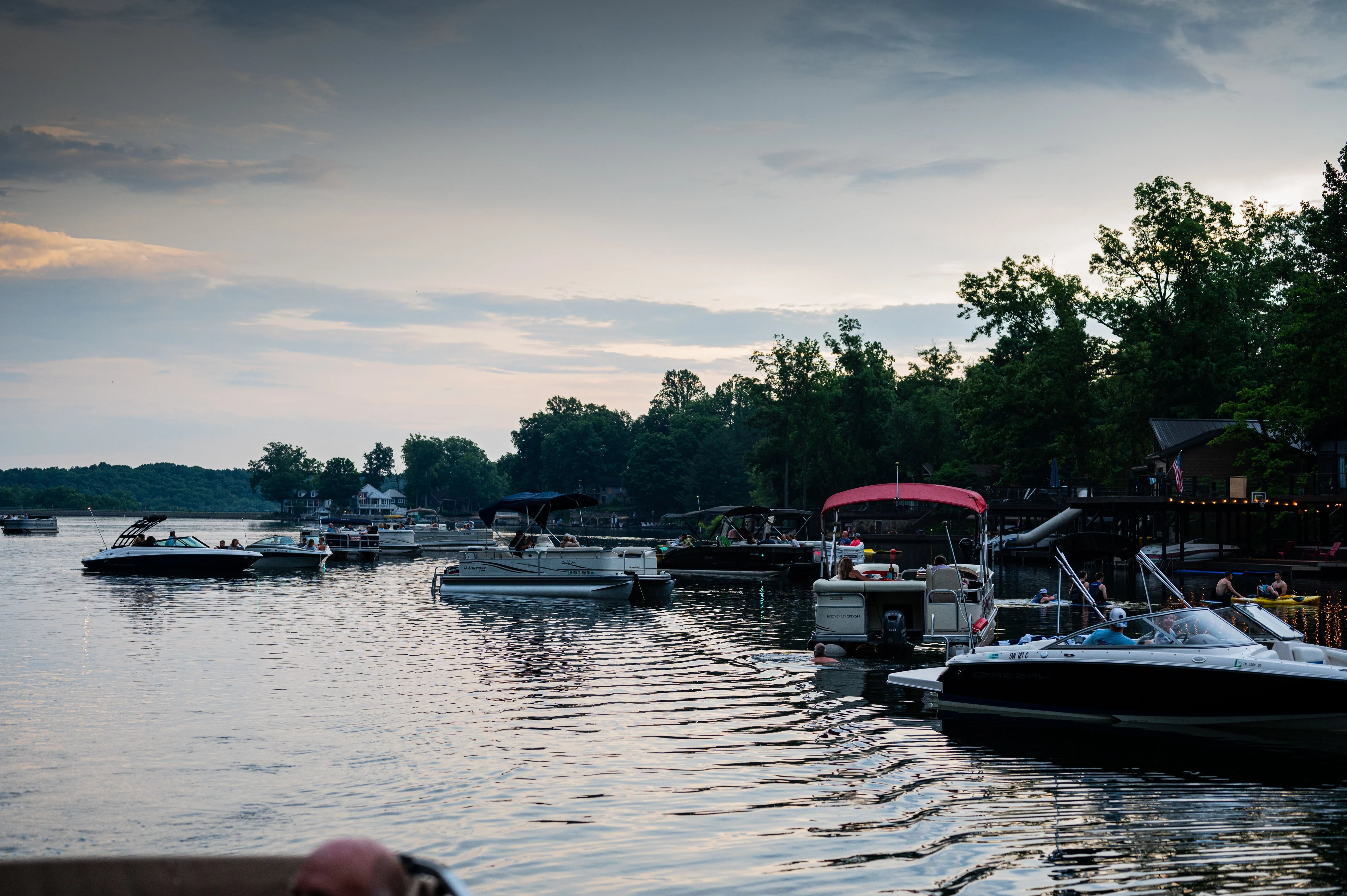 Serene lakeside with docked boats under a dusky sky.