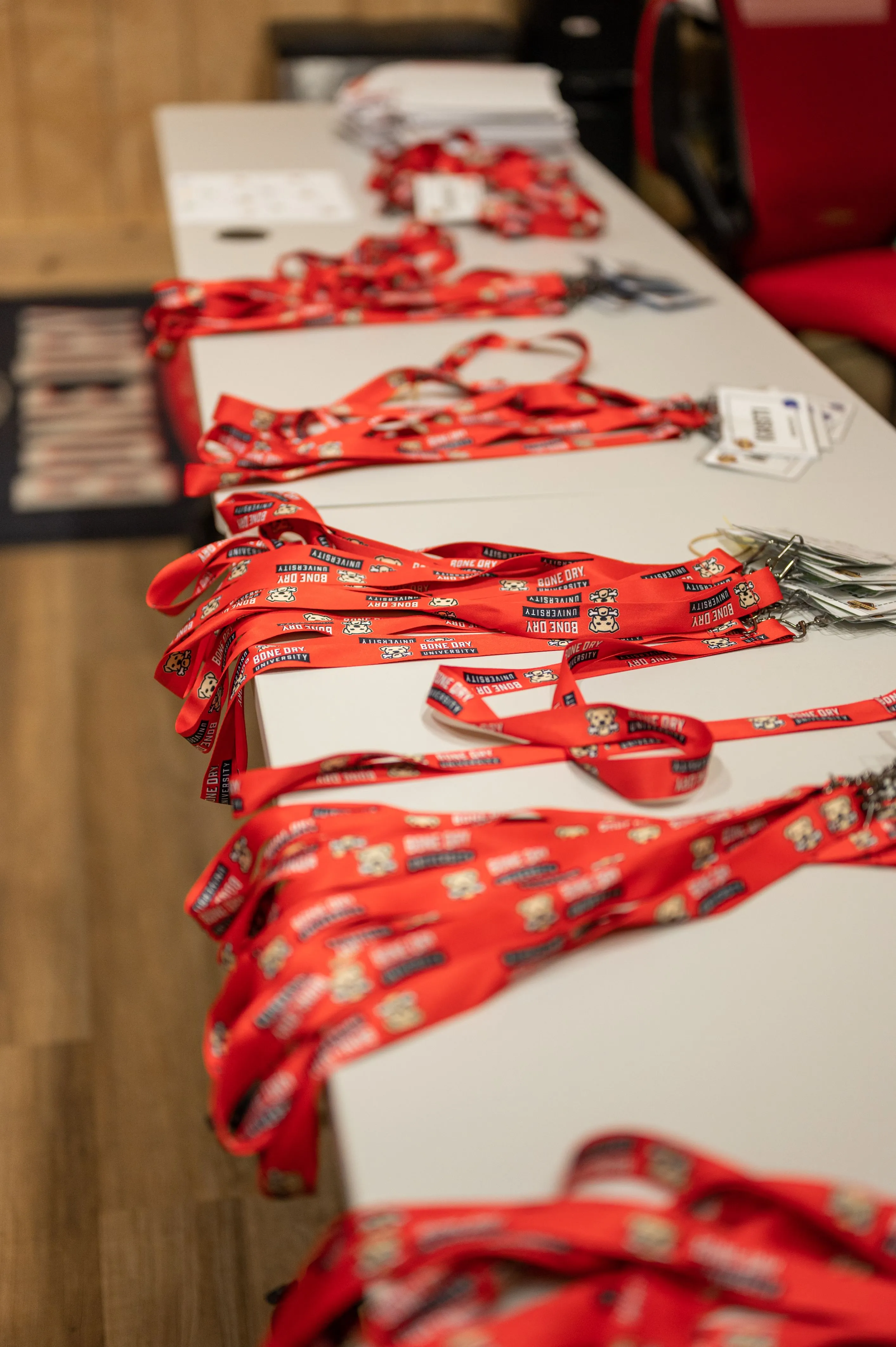 Table with conference name tags and red lanyards laid out in preparation for an event.