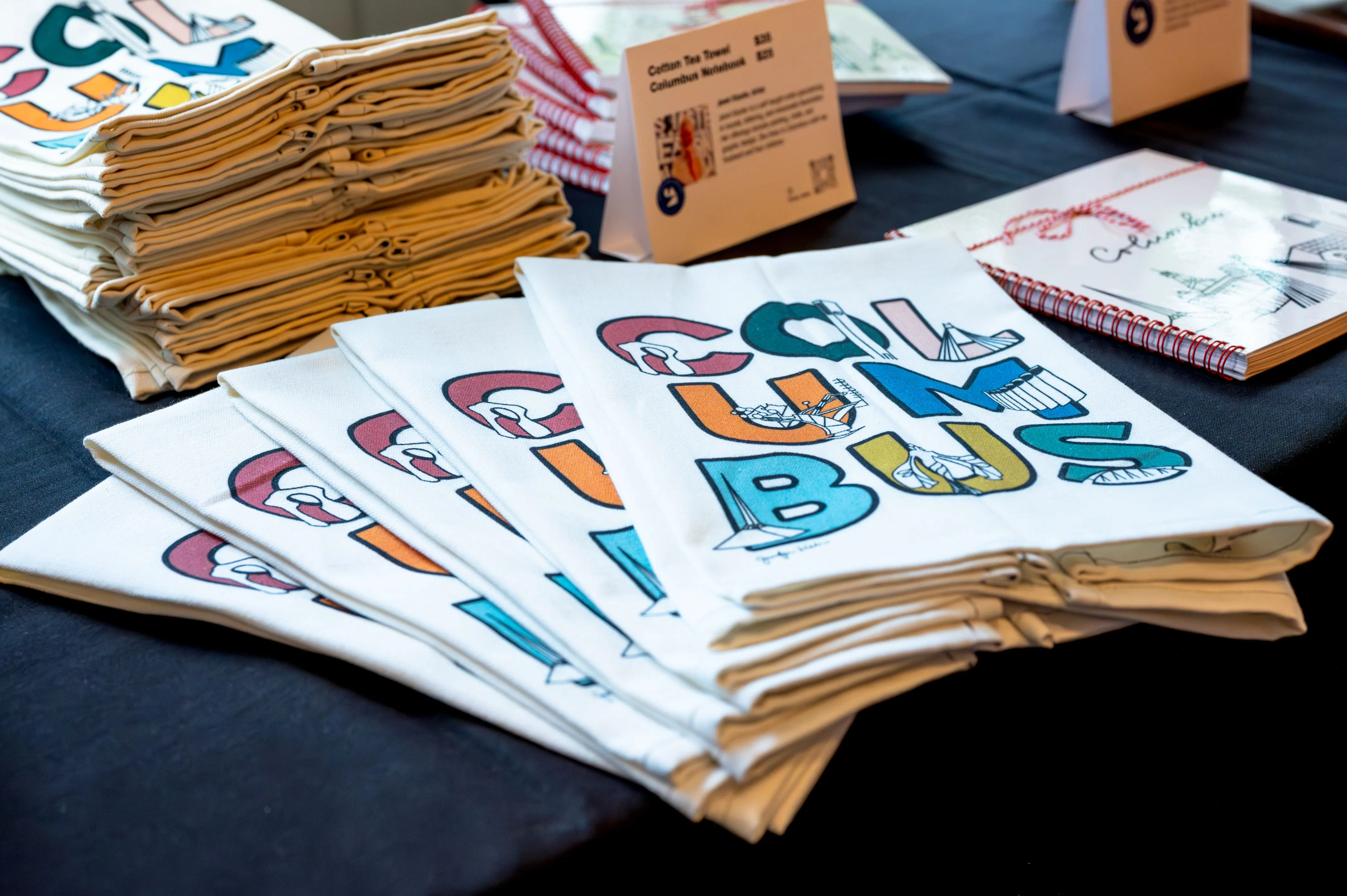 Stacks of colorful brochures with the text "COOL UK BUS" displayed on a table.