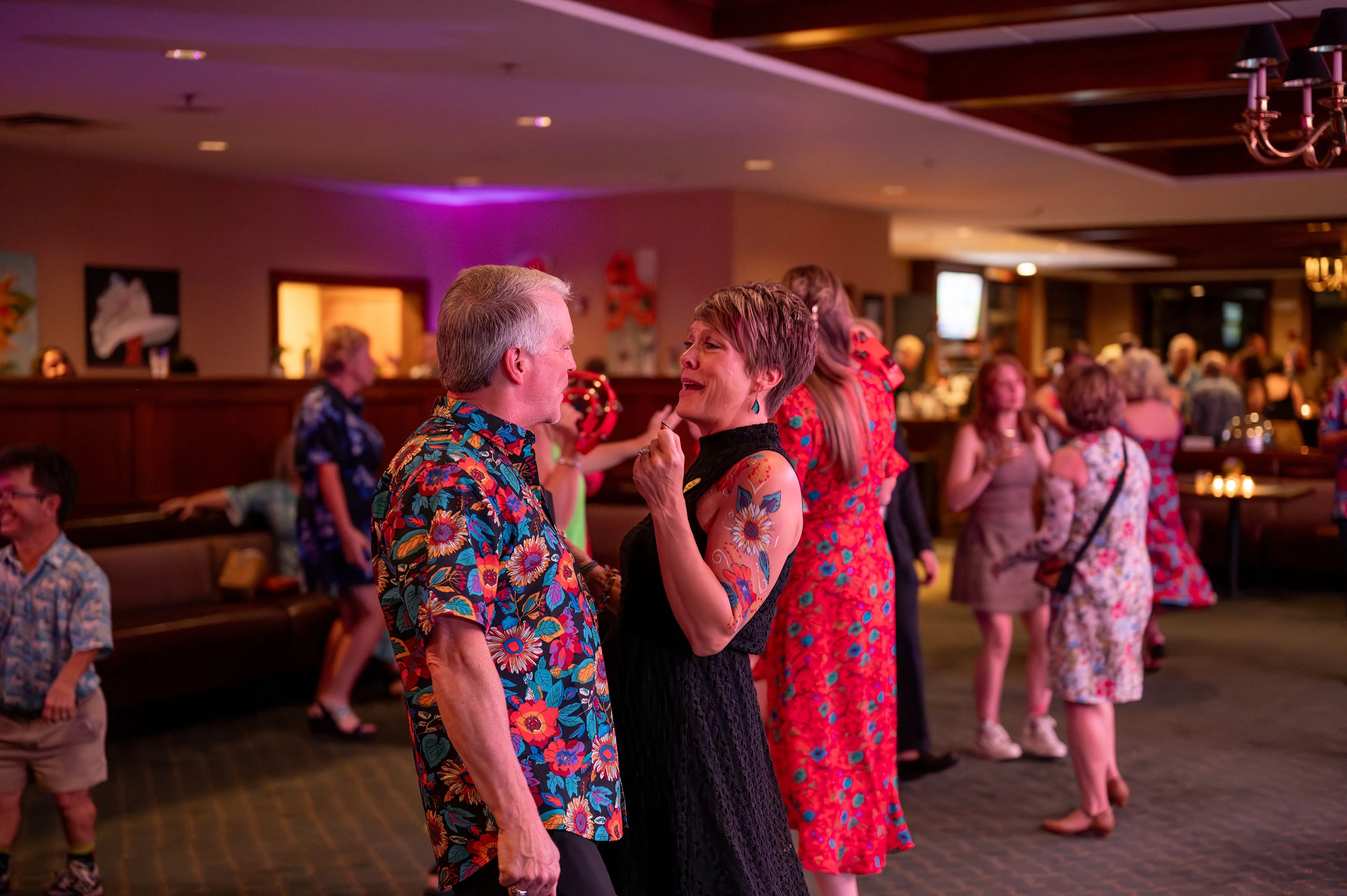 Guests dancing and socializing at an indoor evening event.