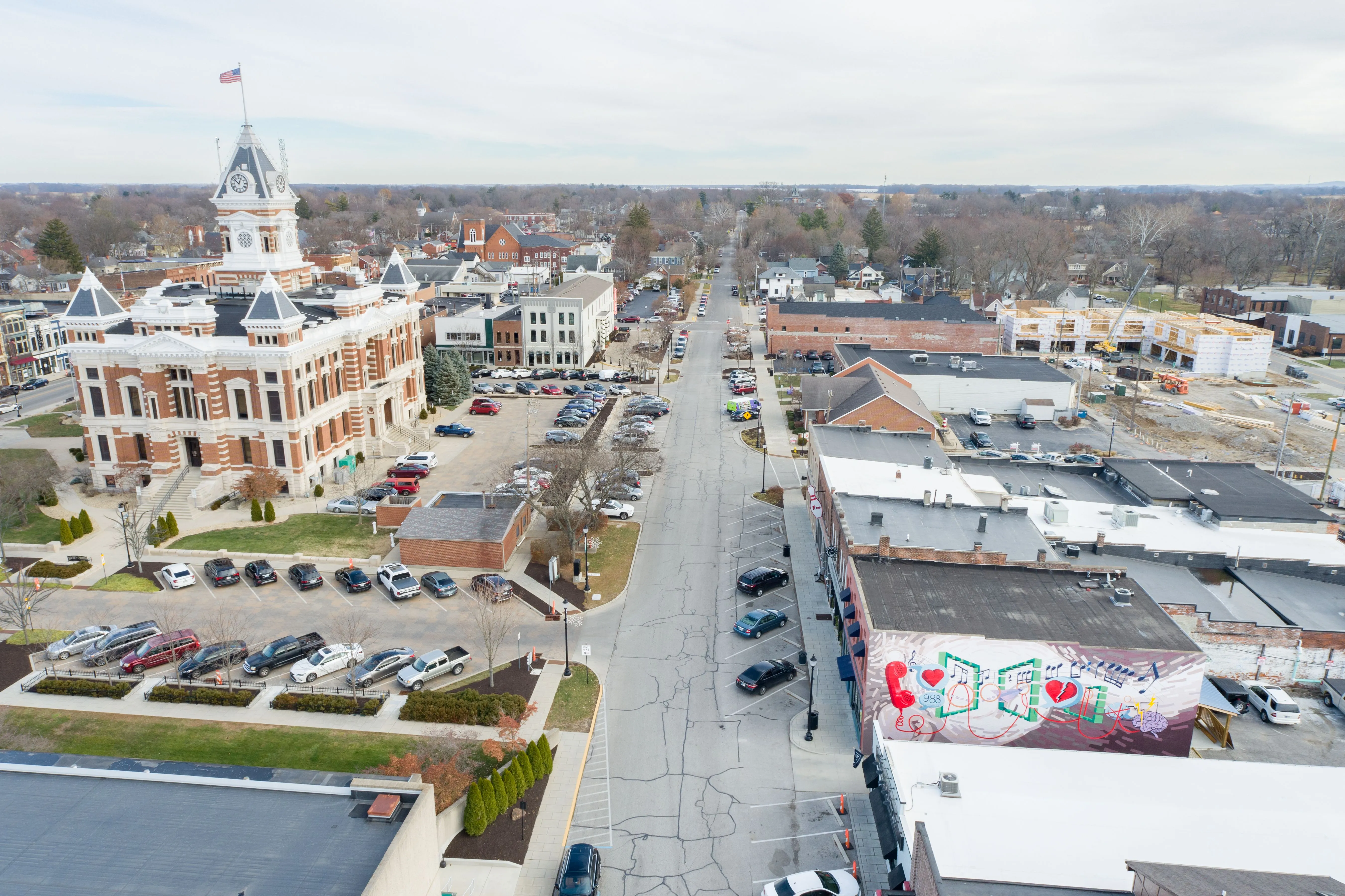 Aerial view of a small town with a prominent courthouse and a main street lined with buildings and parking areas.