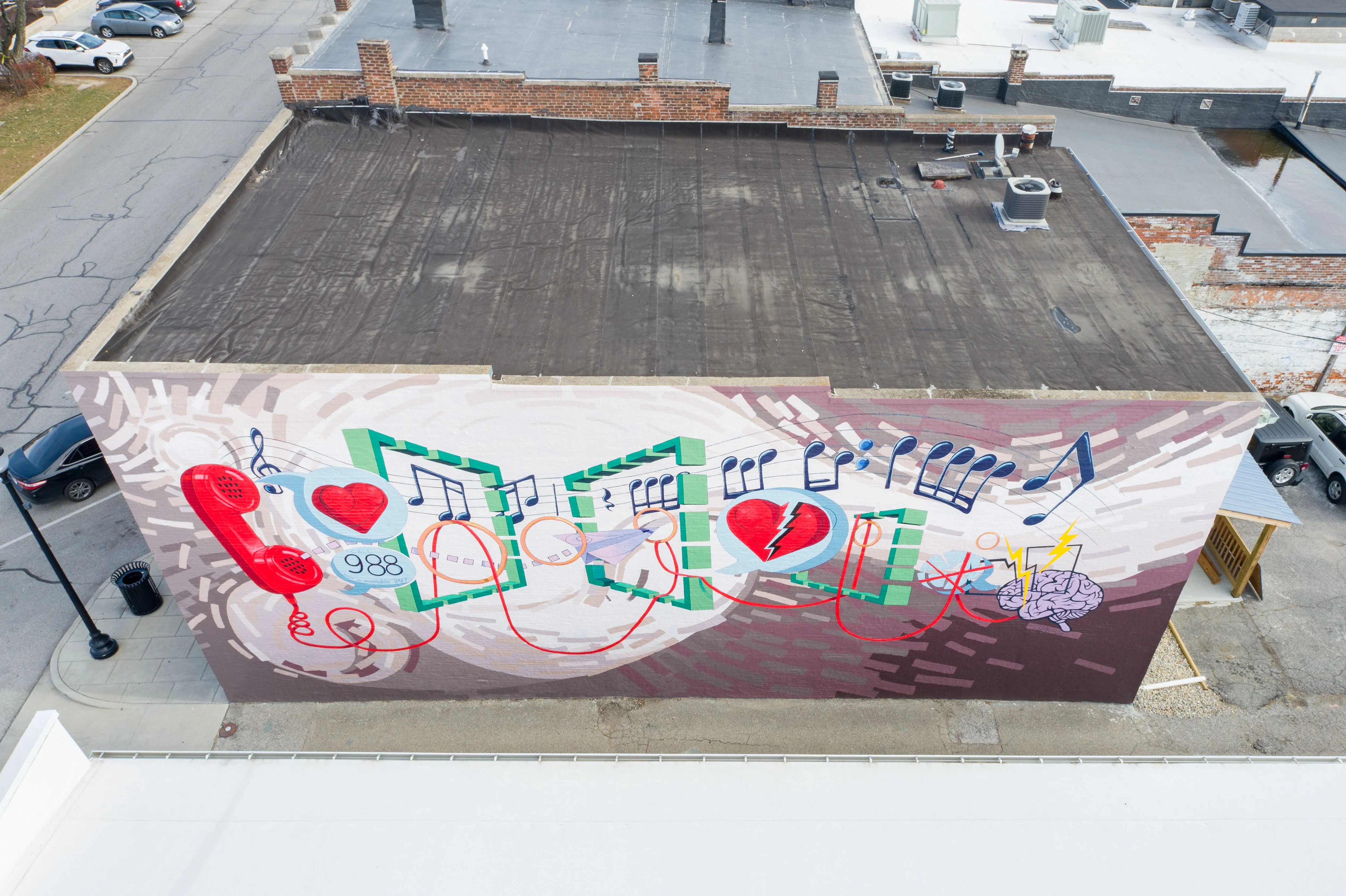 Aerial view of a rooftop with a colorful mural featuring musical notes and hearts.