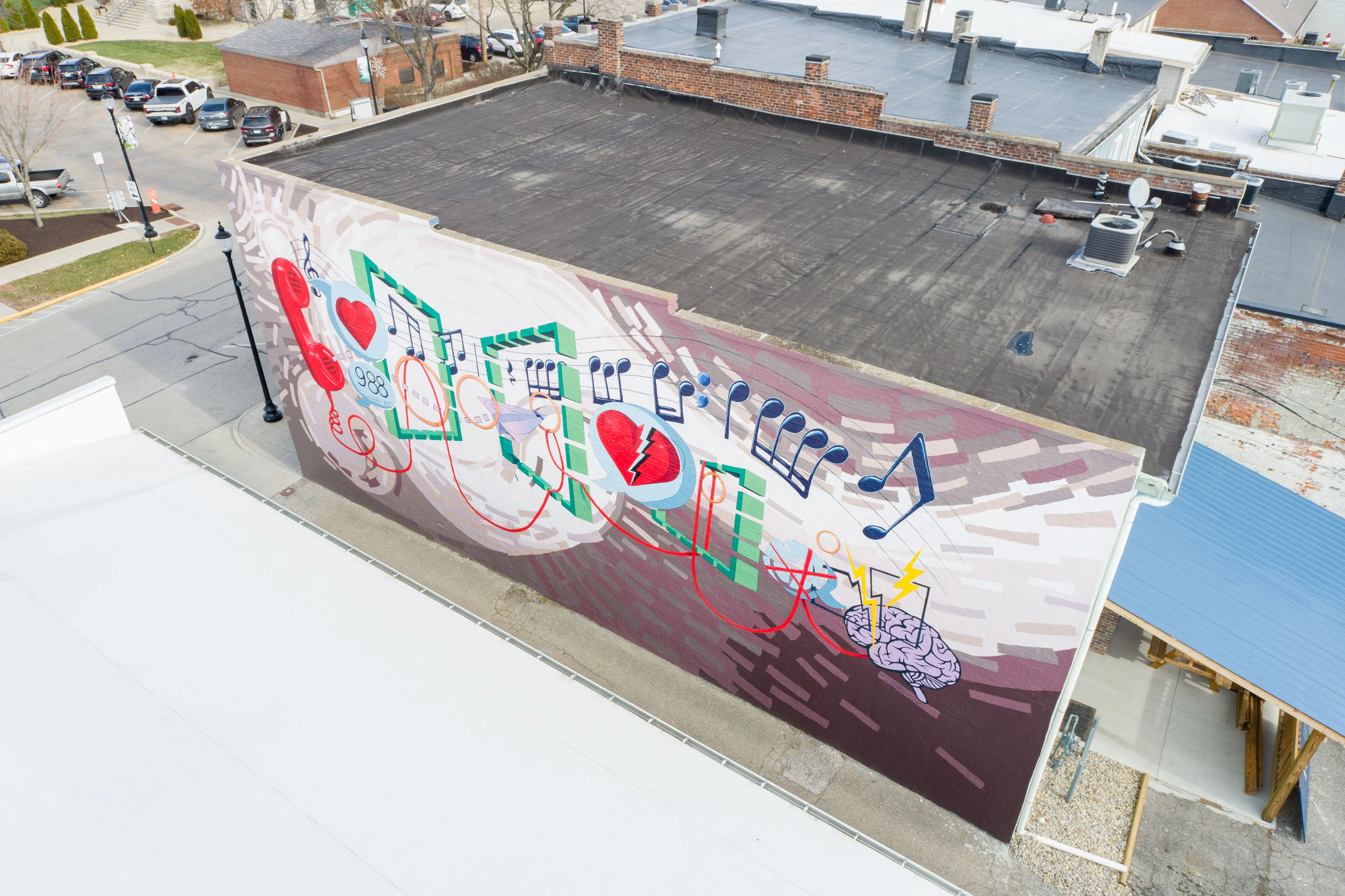 Aerial view of a building rooftop with a large, colorful graffiti mural.