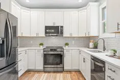 Modern kitchen interior with white cabinetry, stainless steel appliances, and subway tile backsplash.