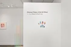 Art gallery interior with Ethereal Themes & Cat Art Show text on wall, featuring artworks of cats and abstract designs.