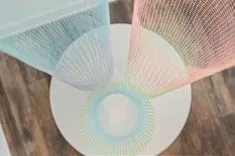 Three compact discs reflecting multi-colored light patterns on a wooden surface.