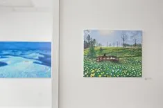 Two paintings on a wall, one depicting an underwater seascape and the other showing a landscape with flowers and a bench.