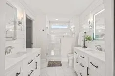 Modern bathroom interior with white finish, two vanities, and a walk-in shower.