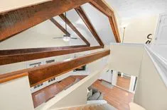 Interior view of a modern staircase with wooden steps and white walls in a residential home.