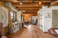 Cozy rustic interior of a home with wooden floors and ceiling beams, furnished with a mix of modern and traditional decor.