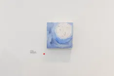 Abstract blue and white painting displayed on a gallery wall with an information placard to the side.