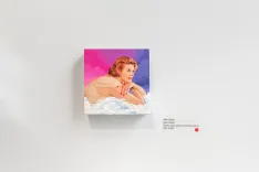 Gallery wall featuring a canvas print of a vintage-styled painting depicting a woman bathing, with a playfully alluring expression, against a vibrant pink and blue background.