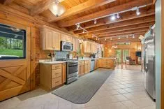 Cozy wooden cabin interior with a fully equipped kitchen and open floor plan.