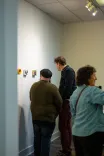 Three people viewing art in a gallery.