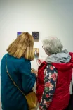 Two women viewing art pieces in a gallery.