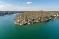 Aerial view of a lakeside community with houses and docks surrounded by leafless trees.