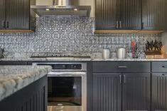 Modern kitchen interior with granite countertops and gray cabinetry.