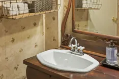 Elegant bathroom interior with wooden vanity cabinet, white sink, and mirror.