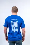 Man standing with his back to the camera, wearing a blue t-shirt with the word "UNBREAKABLE" and a stylized American flag graphic.