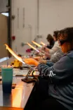 People engaging in glassblowing with torches at a workshop.