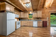Interior of a modern kitchen with wooden cabinets, stainless steel appliances, and hardwood floors.