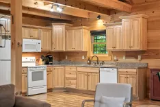 Cozy wooden cabin kitchen interior with natural light, featuring wooden cabinets and modern appliances.