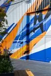 Colorful geometric mural on building exterior with blue and orange patterns.