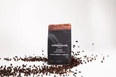 A package of Coffeehouse Five coffee surrounded by scattered coffee beans on a white background.