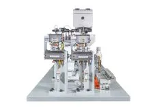 Industrial automated machine with various mechanical components on a gray platform, isolated on a white background.
