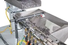 Industrial automated fastener sorting and feeding system with bulk hopper full of screws.